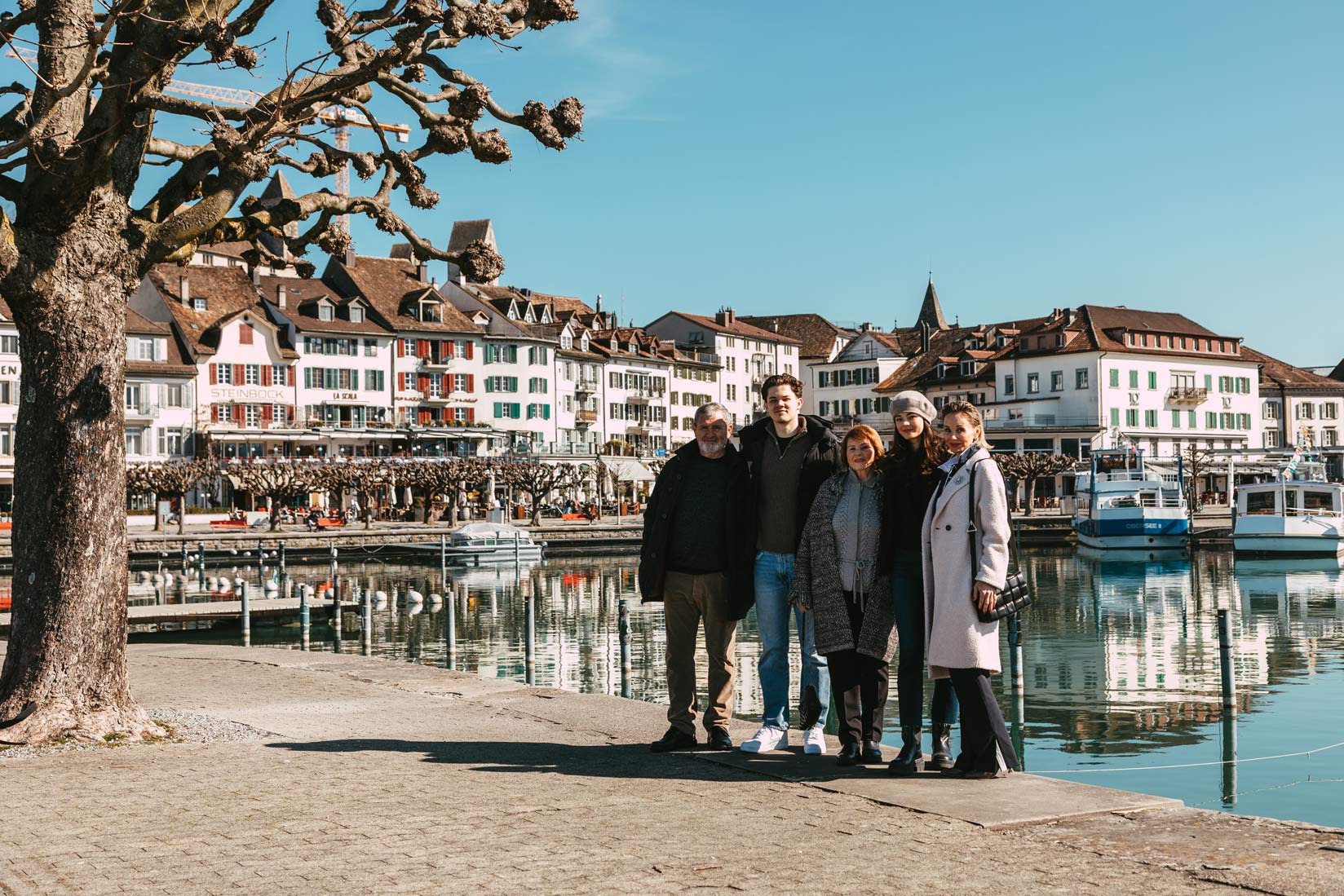 Ein Fotograf fängt eine Gruppe von Menschen ein, die vor einem See in Rapperswil Jona, Schweiz, posieren.