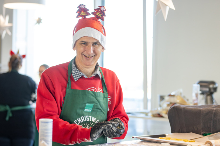 A man with a Christmas hat and apron.