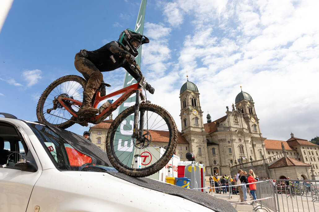 Eine Person fährt mit dem Fahrrad auf dem Dach eines Autos.