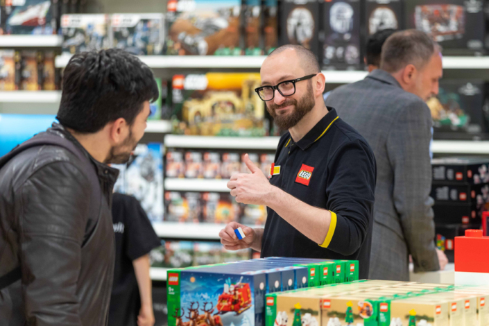 A man looks at Lego boxes in a store.