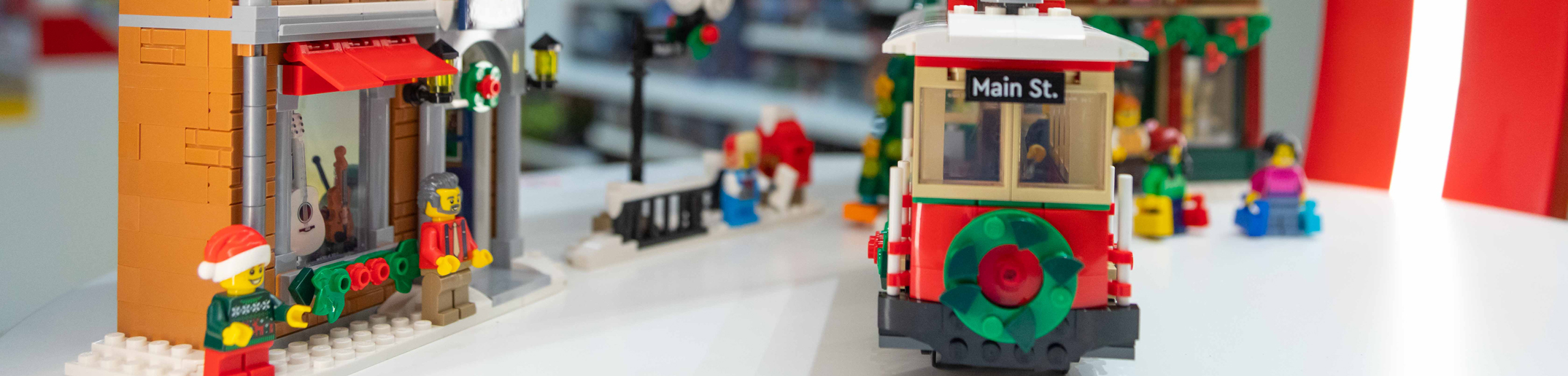 A Lego train stands on a table in a store.
