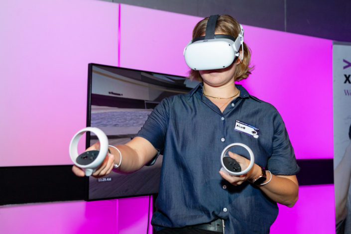 A woman wearing a VR headset at an event.