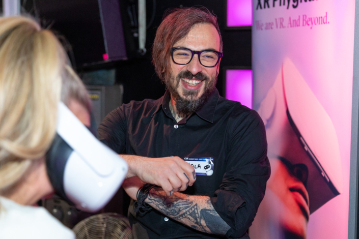 A man with glasses and a tattoo smiles at a woman.