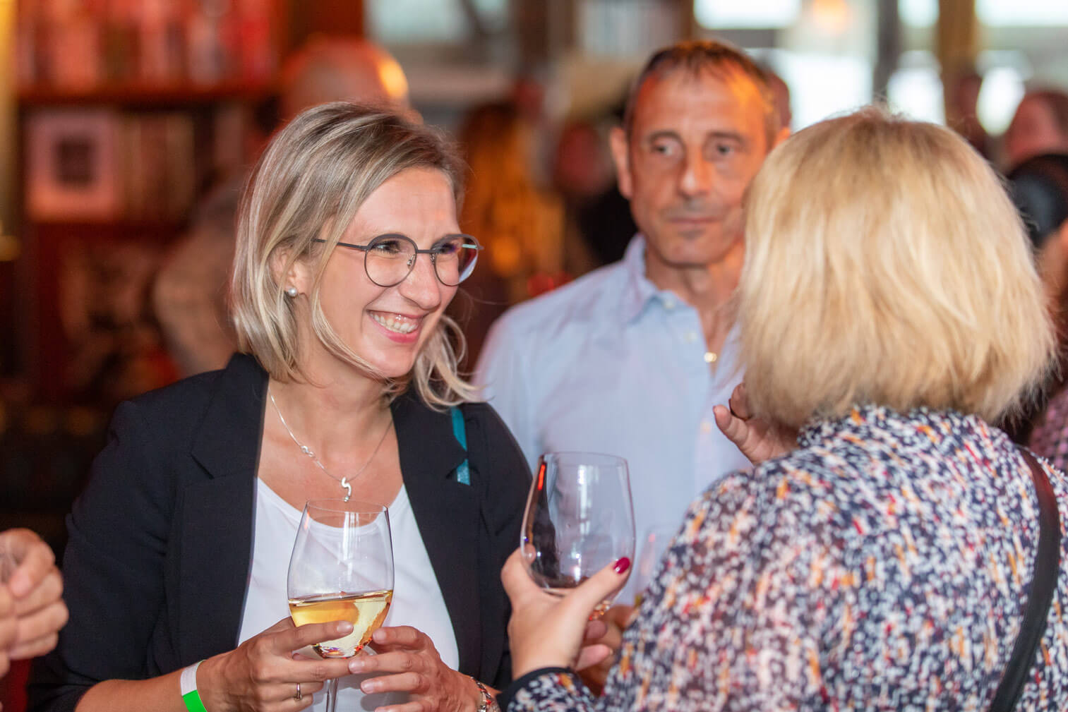 A group of people drink wine at a party.