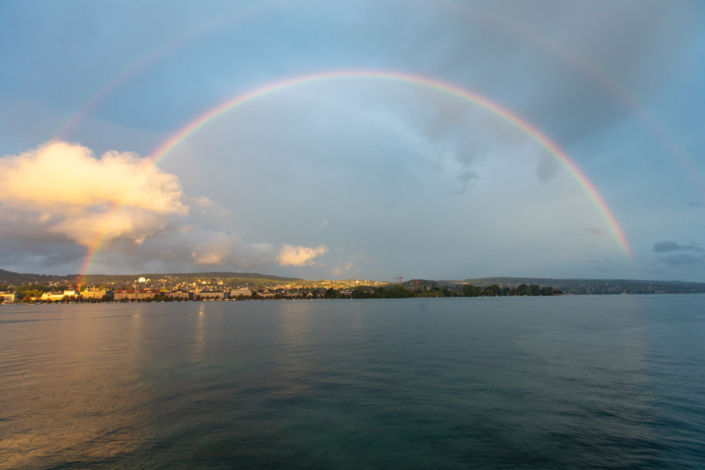 A double rainbow over a body of water.