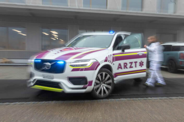 Ein Krankenwagen des Typs Volvo XC90 fährt die Straße entlang.