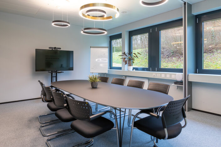 A conference room with a large table and chairs.