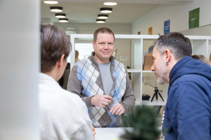 A group of people in an office talking to each other.