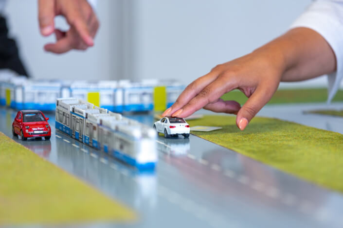 A person points to a toy car on a table.