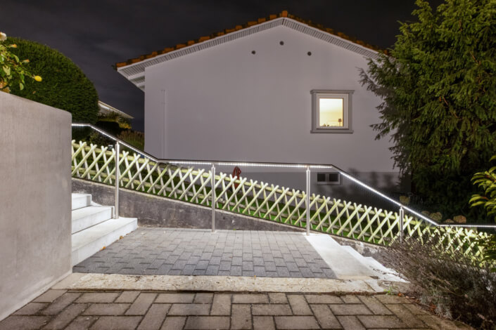 A staircase leads to a house at night.