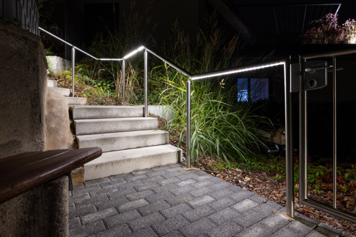 A staircase that leads into a garden at night.