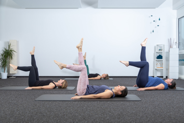 A group of women doing yoga in a room.