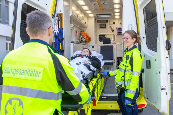 An ambulance with a man on a stretcher.