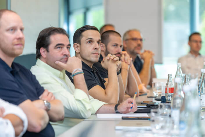 Eine Gruppe von Menschen sitzt an einem Konferenztisch.