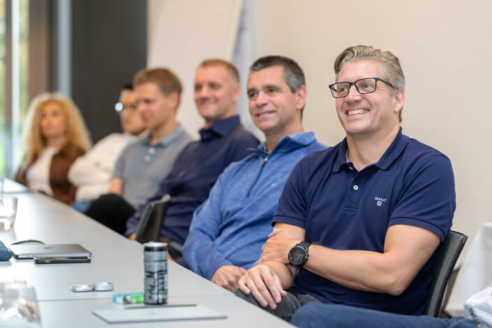 Eine Gruppe von Menschen sitzt an einem Konferenztisch.