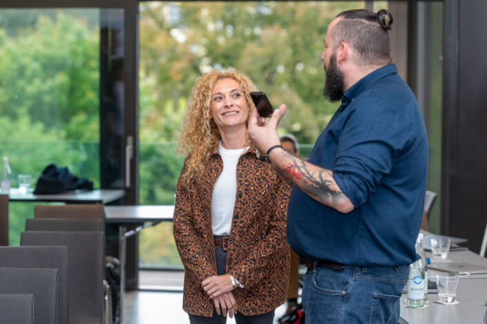 A man with a beard talks to a woman.